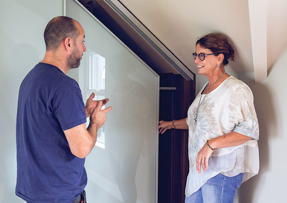 Sliderobes Fitter with Customer in Front of Angled Door Sliding Wardrobe