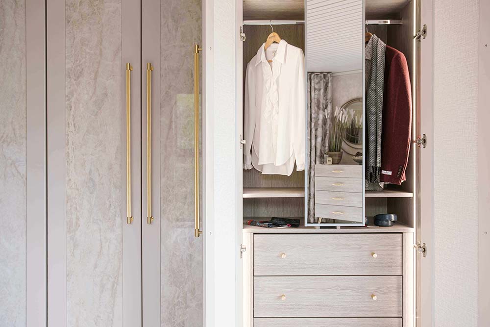 close up of hinge unit with pull out mirror and clothes hanging on rail